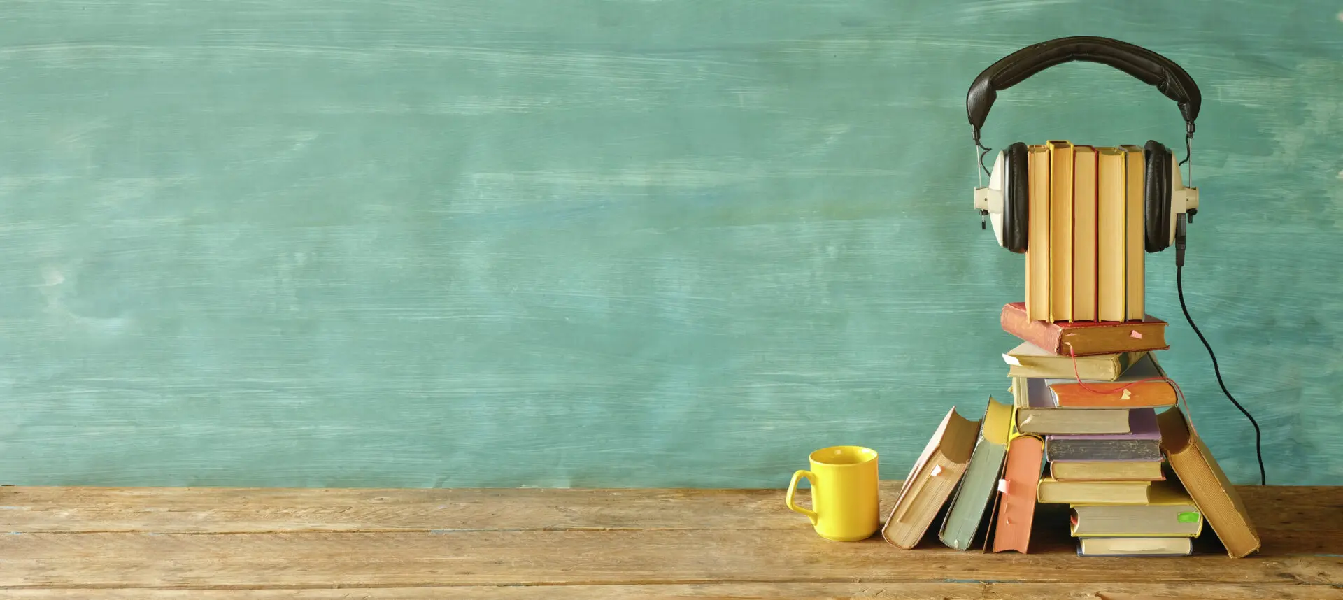 audio book concept, with stack of books, headphones,and cup of coffee, good copy space